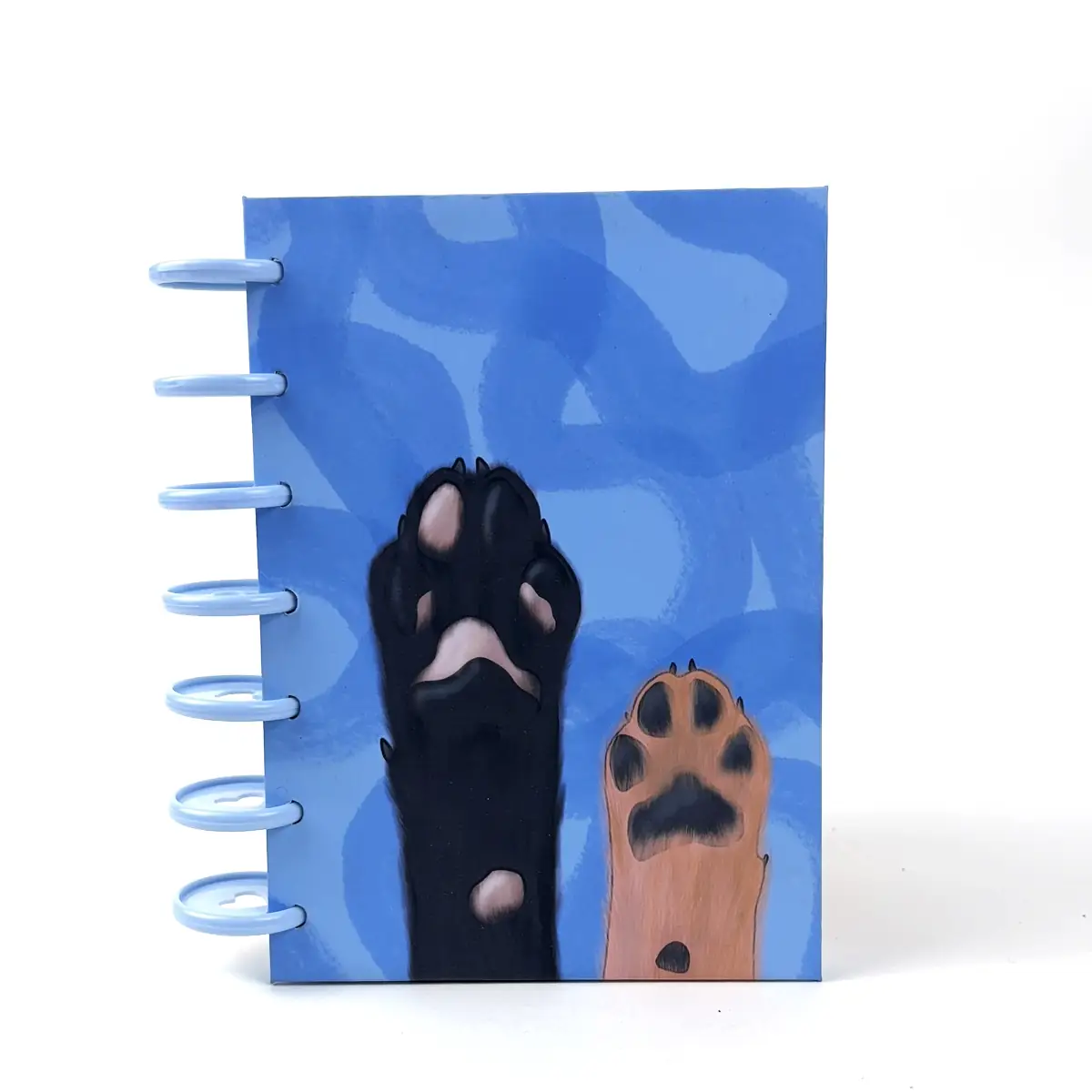 Libreta B6 Paws azul con diseño de patitas y discos laterales